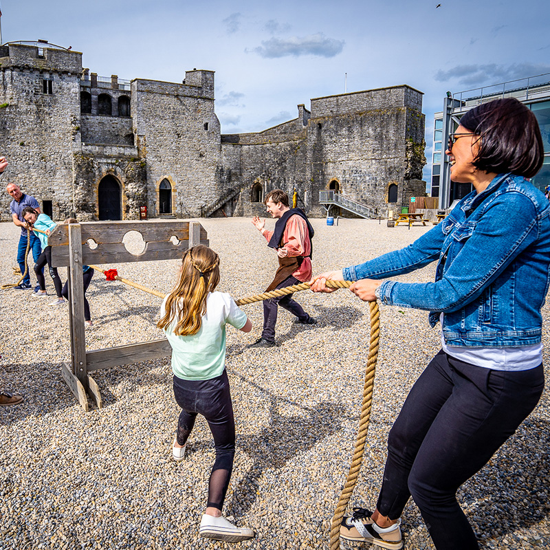 Visitors enjoying Medieval Games tug of war during tour at King John's Castle
